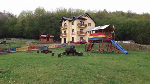 a large house with a playground and a slide at Pensiunea Lavinia in Calvini