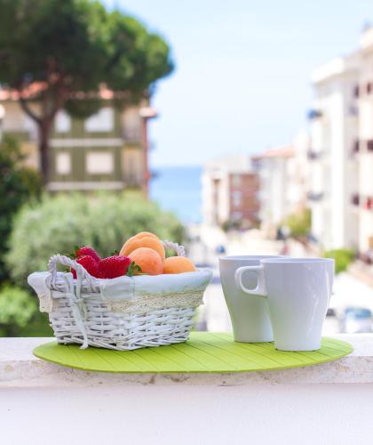 a basket of fruit and two cups on a table at Case Vacanze Ganimede in Sperlonga
