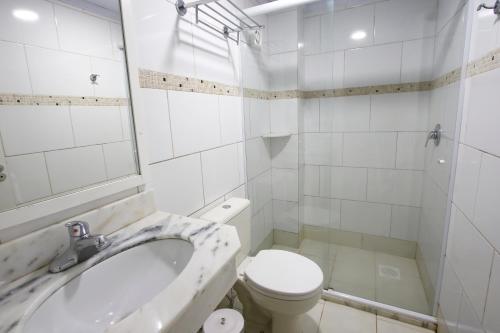 een witte badkamer met toilet en ligbad bij Life Hotel Infinity in Gramado