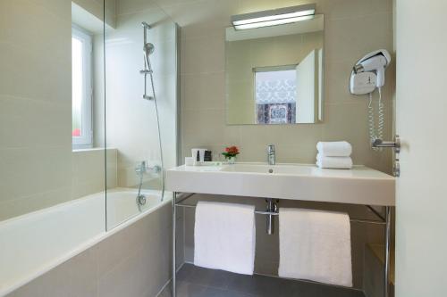 a bathroom with a sink and a shower at Hotel Monceau Wagram in Paris