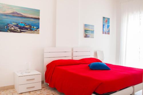 a bedroom with a red bed with a blue pillow at Case Vacanze Ganimede in Sperlonga