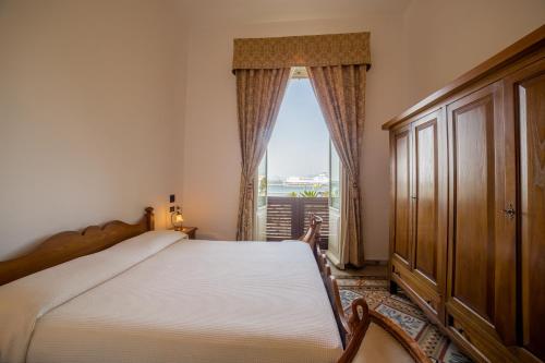 a bedroom with a bed and a large window at Hotel AeR BJ Vittoria in Cagliari