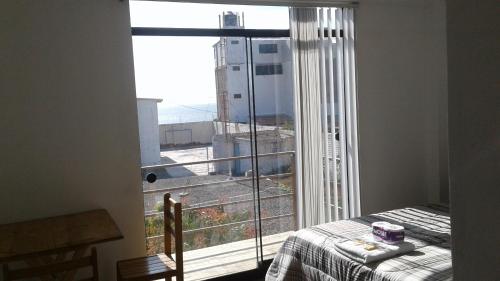 Un dormitorio con una ventana con vista a una ciudad. en Chicama Surf Camp, en Puerto Chicama