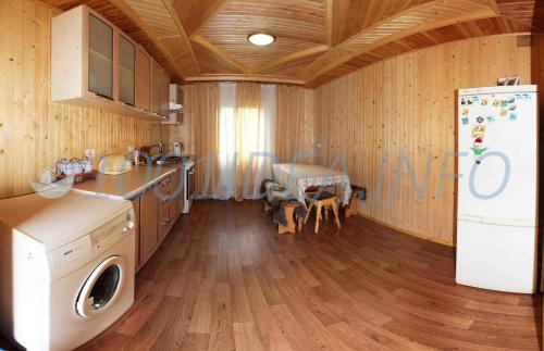 a kitchen with a refrigerator and a table in it at Medova Hata in Mykulychyn