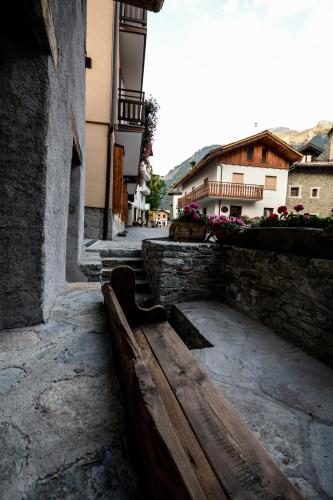 a wooden bench sitting next to a building at Hotel Du Grand Paradis - 1899 Auberge Boutique in Cogne