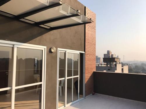 a balcony with glass doors on a building at 9 de Julio Park Suites in San Miguel de Tucumán