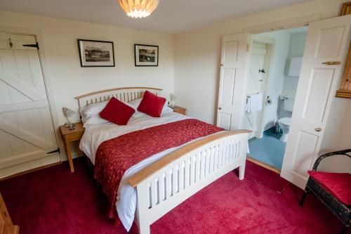 1 dormitorio con cama blanca y alfombra roja en The Wild Atlantic Hideaway, en Clonakilty