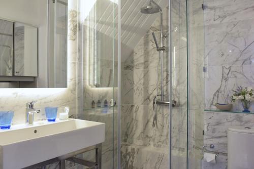 a bathroom with a sink and a shower at Mon Repos Liston Suites in Corfu Town