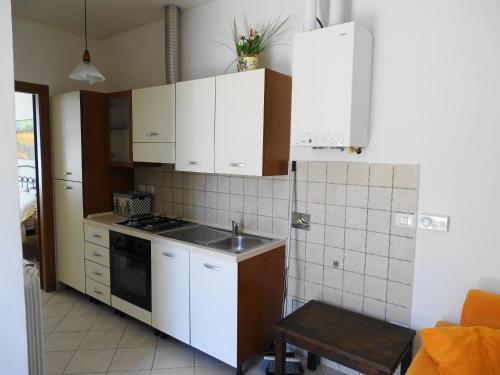 a small kitchen with white cabinets and a sink at Residence Terra Dei Santi Country House in Spello