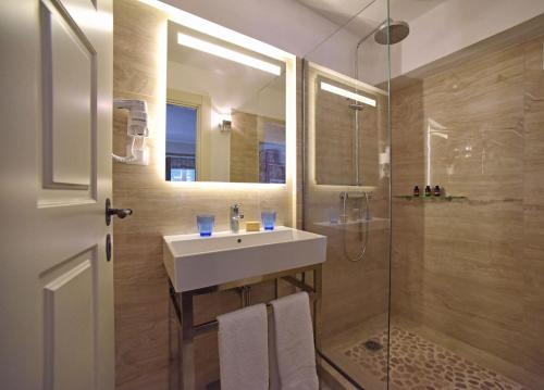 a bathroom with a sink and a shower at Durrell Liston Suites in Corfu Town
