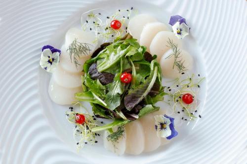 a plate of food with vegetables and flowers on it at ibis Styles Le Mans Sud Mulsanne in Mulsanne