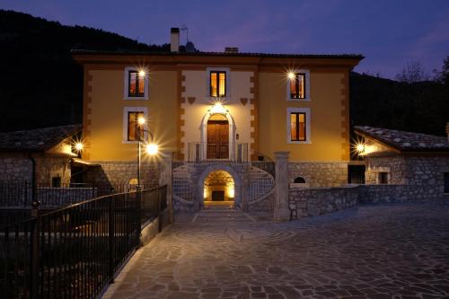 Una casa grande con luces por la noche en Casale Alberico en Caramanico Terme