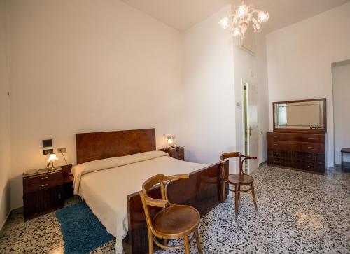 a bedroom with a bed and two chairs and a chandelier at Hotel AeR BJ Vittoria in Cagliari