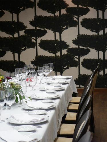 a long table with white plates and wine glasses at Posada Real Los Cinco Linajes in Arévalo