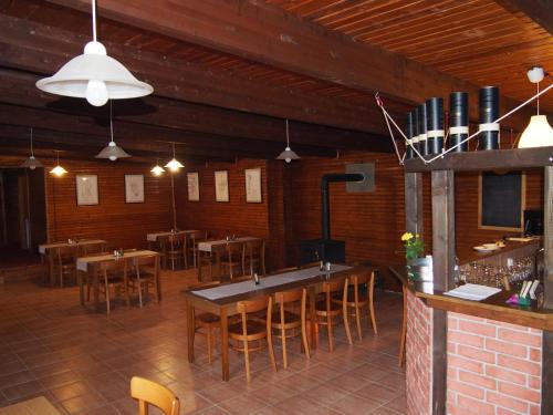 Libuň的住宿－Kemp Prachovská osma，一间带桌椅的餐厅和一间酒吧