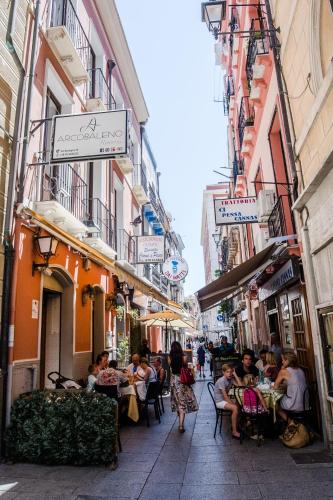 a group of people sitting at tables on a city street at Hotel AeR BJ Vittoria in Cagliari