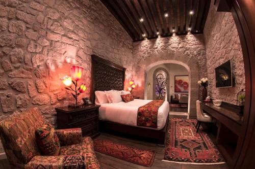 a bedroom with a bed and a stone wall at Hotel De La Soledad in Morelia