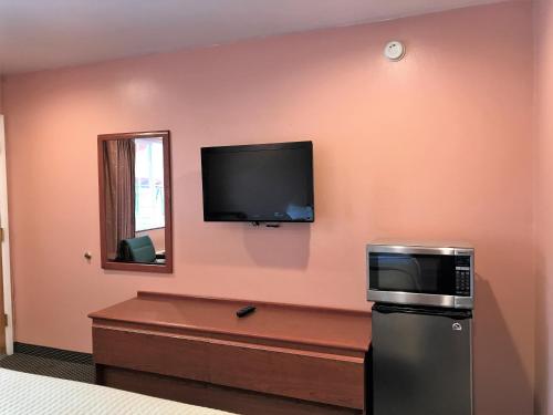 Zimmer mit einer Mikrowelle und einem TV an der Wand in der Unterkunft Bestway Inn in Grants Pass