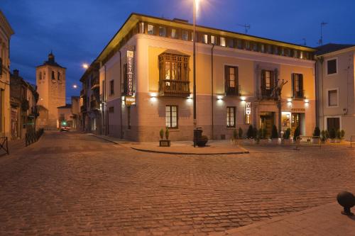 a building on a cobblestone street at night at Posada Real Los Cinco Linajes in Arévalo