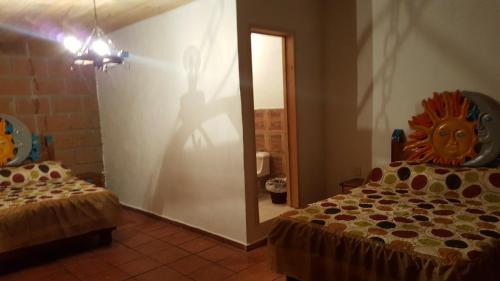 a room with two beds and a persons shadow on the wall at Hotel Jardin Rincon de las Estrellas in Velasco
