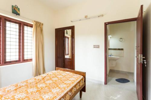 a bedroom with a bed and a bathroom at Stay at DBRA 61 Don Bosco Cross Road Vaduthala Ernakulam in Cochin