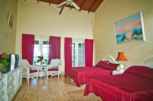 um quarto com duas camas e uma televisão em Silver Seas Hotel em Ocho Rios