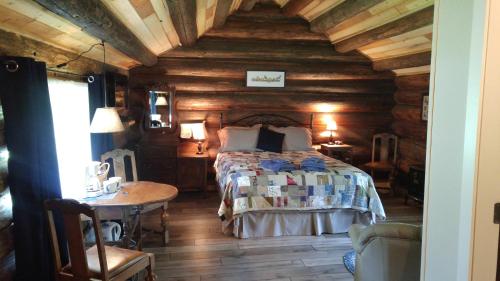 a bedroom with a bed in a wooden cabin at Wolfwood Guest Ranch in Clearwater