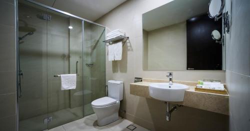 a bathroom with a toilet and a sink and a shower at d'Sora Boutique Business Hotel in Kampong Baharu Jimah