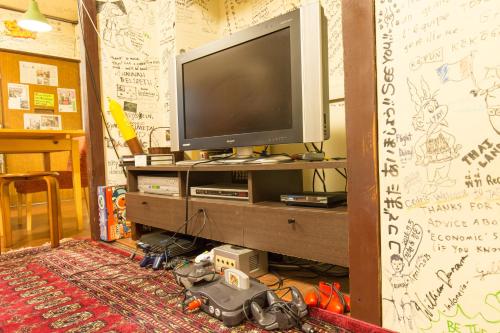 a living room filled with furniture and a television at Backpackers Hotel Toyo in Osaka