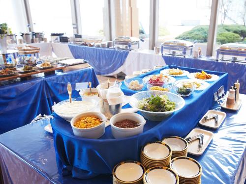 a blue table topped with bowls and plates of food at Hotel Seagull Tenpozan Osaka in Osaka