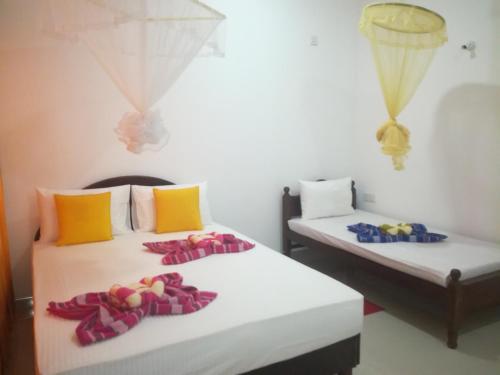 two beds in a room with towels on them at The Sigiri Roar in Sigiriya