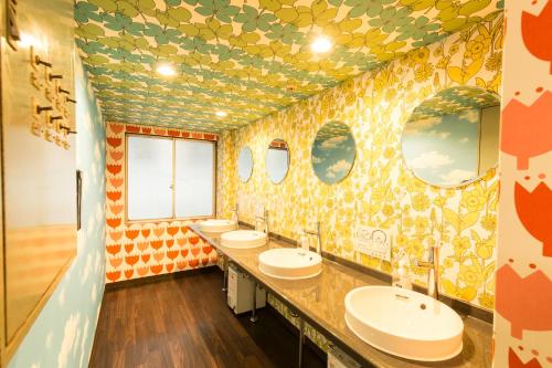 a bathroom with four sinks and a bunch of mirrors at Backpackers Hotel Toyo in Osaka