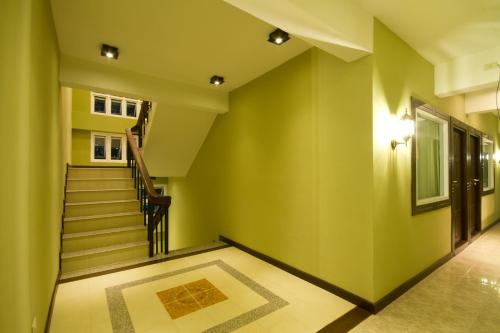 an empty hallway with stairs and green walls at Rommai Greenpark in Lampang