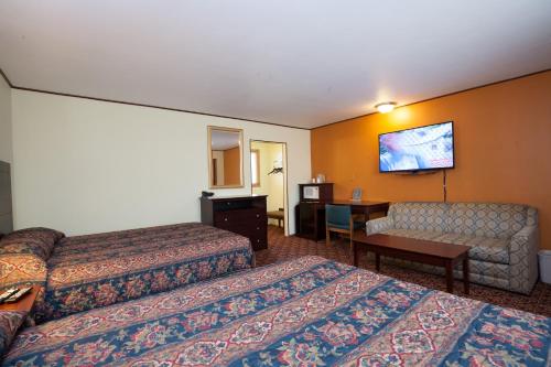 a hotel room with two beds and a desk at Park Motel in Marshfield
