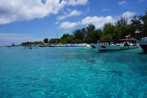 a group of boats are docked in the water at M BOX Gili Trawangan in Gili Trawangan