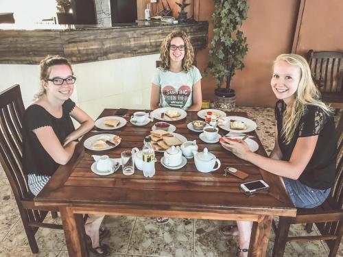 three girls sitting at a table eating breakfast at Anon Rest in Dambulla