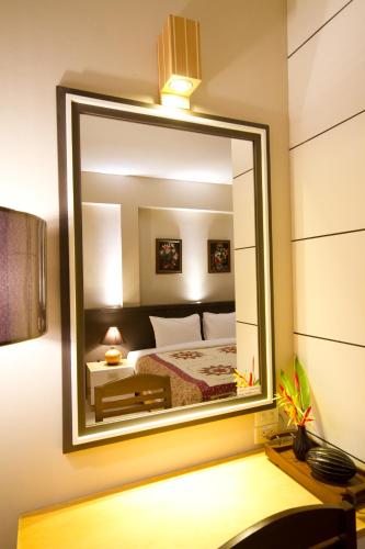 a bedroom with a large mirror on the wall at Rommai Greenpark in Lampang