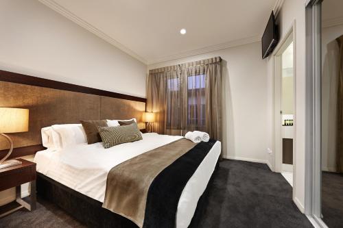 um quarto de hotel com uma cama grande e uma janela em Attika Hotel em Perth