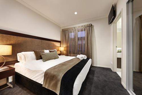 a hotel room with a large bed and a large window at Attika Hotel in Perth