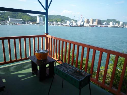 a grill on a deck with a view of the water at Sea Side Hostel Light House in Onomichi