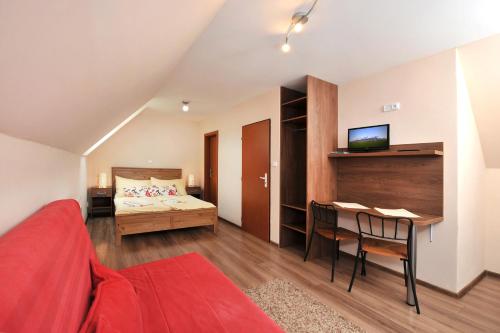a bedroom with a bed and a desk with a television at APLEND Villas Tatry Holiday in Veľký Slavkov