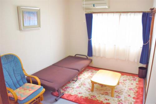 ein Krankenhauszimmer mit einem Bett und einem Stuhl in der Unterkunft Guest House WASSO in Kyoto
