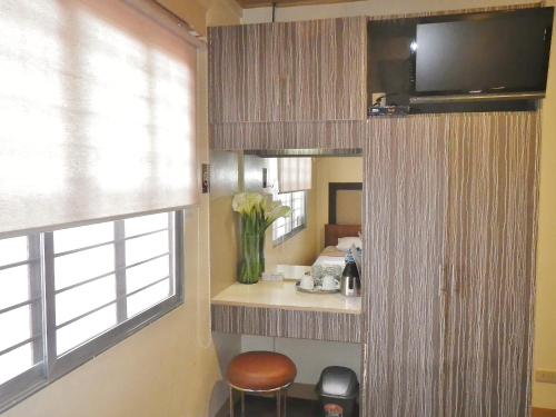 a room with a television and a vase of flowers at Baguio Holiday Villas in Baguio