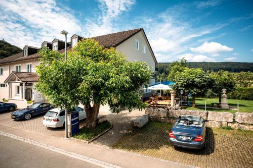 two cars parked in a parking lot next to a house at Hirschenwirt in Eichstätt