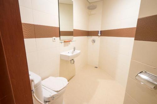 een kleine badkamer met toilet en wastafel bij Front One Hotel Jayapura in Jayapura