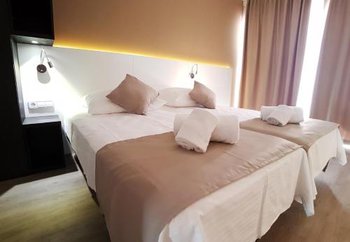 a bedroom with two beds with white sheets and pillows at Planet Hotels ONE - Adults Only 16 years in El Arenal