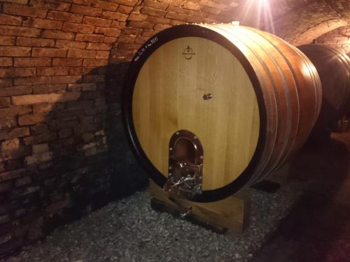 een groot houten wijnvat in een bakstenen muur bij Weingut Wagner in Leodagger