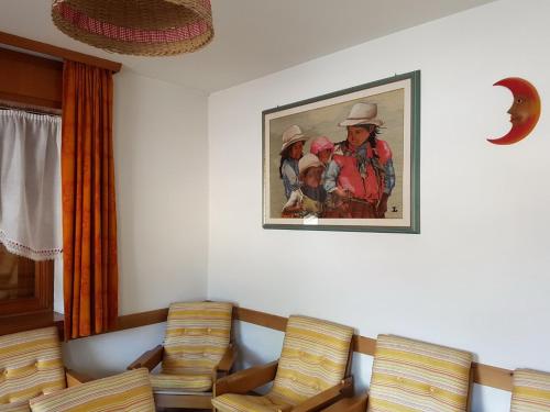 a room with chairs and a painting on the wall at Albergo Posta in Colle Santa Lucia