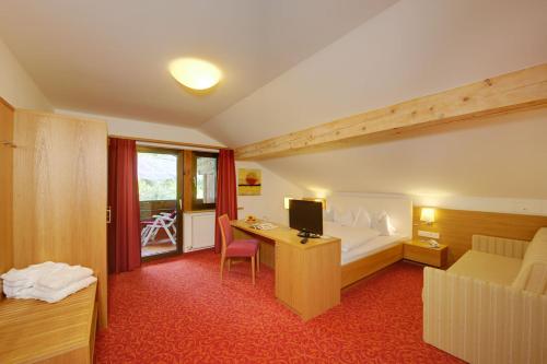 ラグンドにあるHotel Laurinのベッド、デスク、コンピュータが備わるホテルルームです。