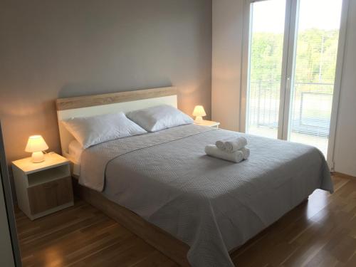 sypialnia z łóżkiem z białym ręcznikiem w obiekcie Apartments Granzola w Sukošanie